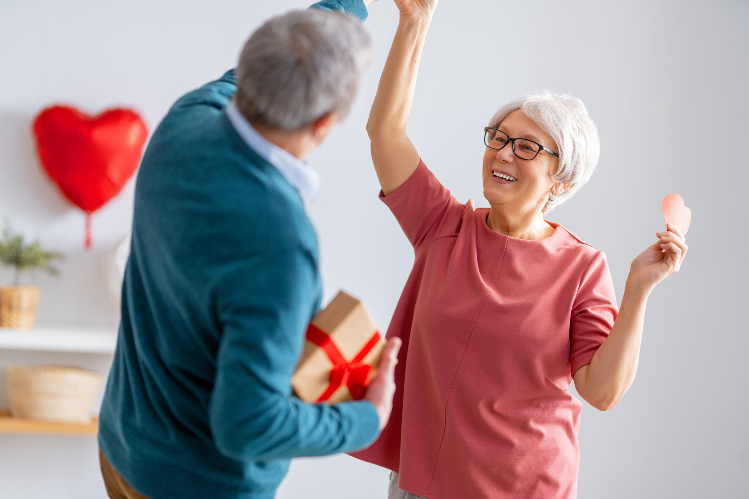 Elderly couple on valentine's day. Joyful nice senior woman dancing with her husband.