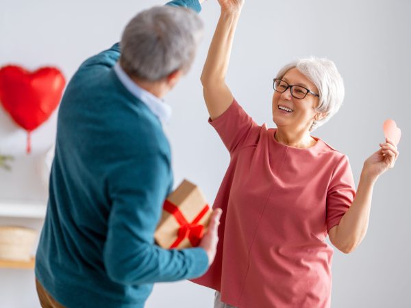 Elderly couple on valentine's day. Joyful nice senior woman dancing with her husband.