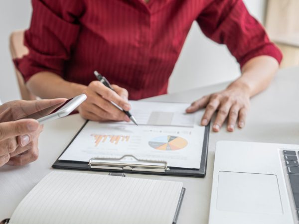 Teamwork of business casual colleagues, consultation new strategy plan business and market growth on financial document graph report, conference to making growth profit, Partner meetings and briefing.